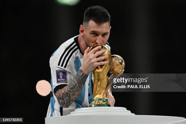 Argentina's captain and forward Lionel Messi kisses the FIFA World Cup Trophy during the trophy ceremony after Argentina won the Qatar 2022 World Cup...