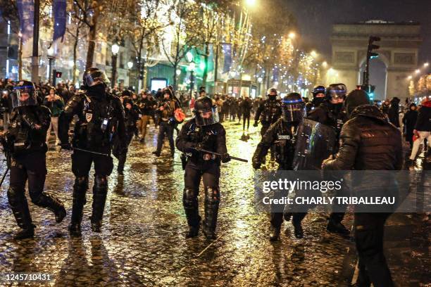 French police officers confront an individual on the Champs-Elysees as football fans gather after France's defeat in the final football match of the...