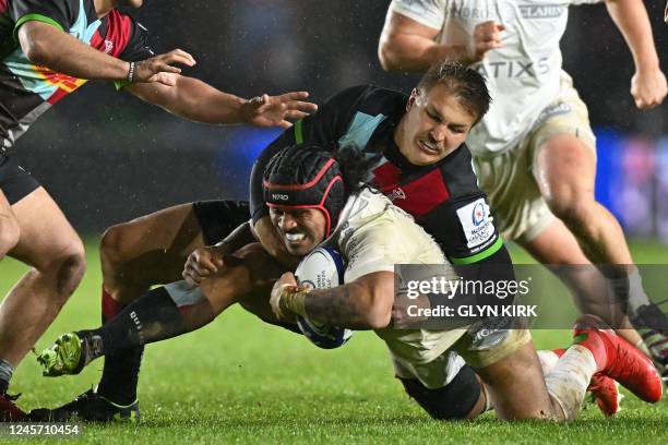 Racing92's New Zealander centre Francis Saili is tackled by Harlequins' South African centre Andre Esterhuizen during the European Rugby Champions...