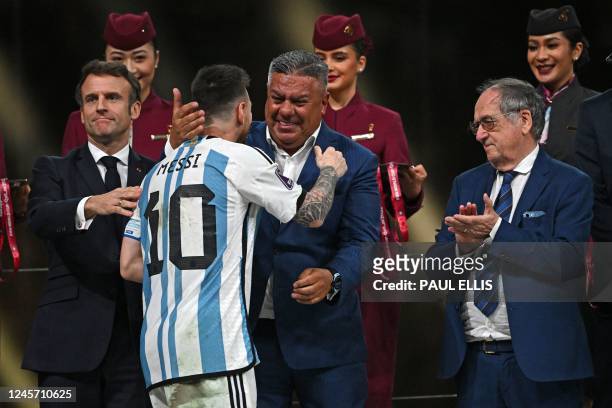 Argentina's forward Lionel Messi is congratulated by the President of the Argentine Football Association Claudio Tapia, next to French President...