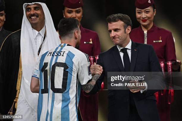Argentina's forward Lionel Messi shakes hands with French President Emmanuel Macron after he received the Golden Ball award for best player from...