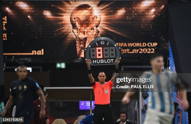 The fourth official holds up the board to indicate 8 extra minutes for injury time during the Qatar 2022 World Cup final football match between...