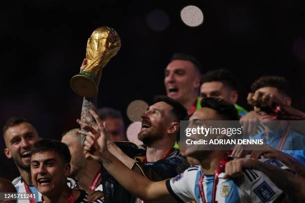 Argentina's captain and forward Lionel Messi lifts the FIFA World Cup Trophy during the trophy ceremony after Argentina won the Qatar 2022 World Cup...