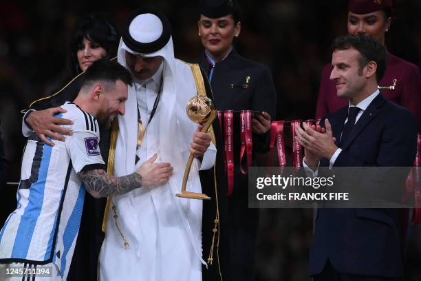Argentina's forward Lionel Messi is greeted by Qatar's Emir Sheikh Tamim bin Hamad al-Thani as French President Emmanuel Macron looks on while...