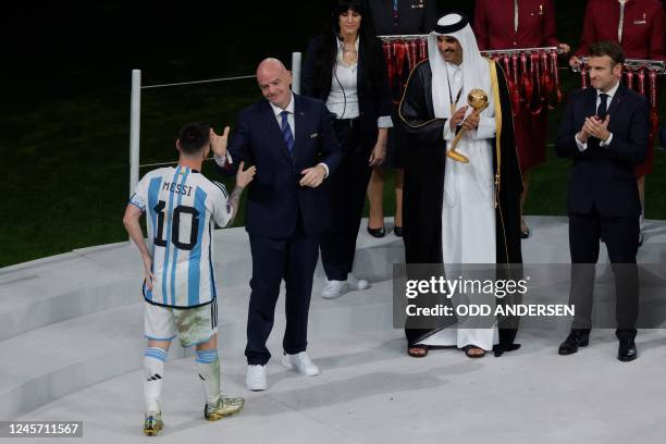 Argentina's forward Lionel Messi is greeted by FIFA President Gianni Infantino before receiving the Golden Ball award from Qatar's Emir Sheikh Tamim...