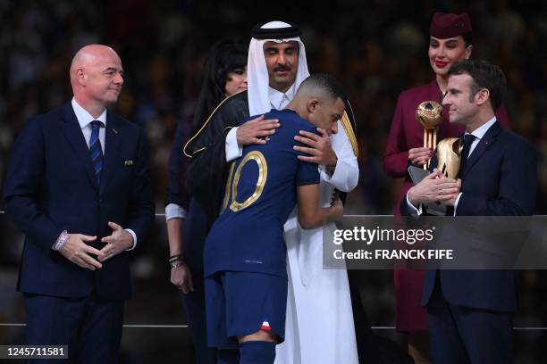 France's forward Kylian Mbappe is greeted by Qatar's Emir Sheikh Tamim bin Hamad al-Thani as FIFA President Gianni Infantino and French President...