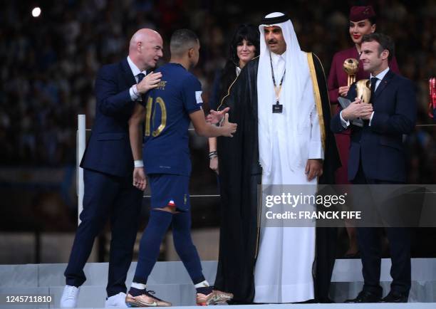 France's forward Kylian Mbappe is greeted by Qatar's Emir Sheikh Tamim bin Hamad al-Thani as FIFA President Gianni Infantino and French President...