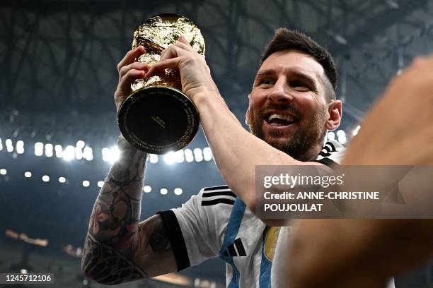 Argentina's captain and forward Lionel Messi holds the FIFA World Cup Trophy following the trophy ceremony after Argentina won the Qatar 2022 World...