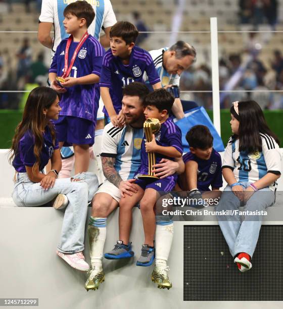 Lionel Messi of Argentina sits with his family & the adidas Golden Ball at the end of the FIFA World Cup Qatar 2022 Final match between Argentina and...