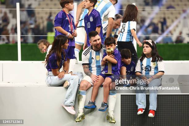 Lionel Messi of Argentina sits with his family & the adidas Golden Ball at the end of the FIFA World Cup Qatar 2022 Final match between Argentina and...