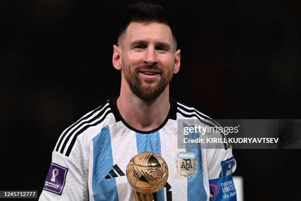 Argentina's forward Lionel Messi poses on stage with the Golden Ball award for best player during the trophy ceremony at the end of the Qatar 2022...