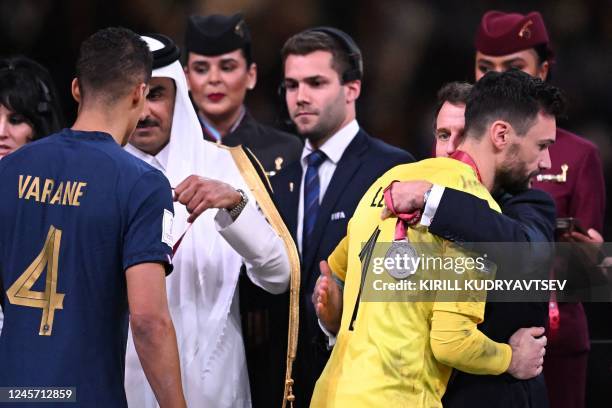 France's defender Raphael Varane receives the silver medal from Qatar's Emir Sheikh Tamim bin Hamad al-Thani as France's goalkeeper Hugo Lloris...