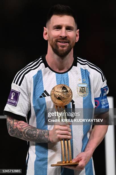 Argentina's forward Lionel Messi poses on stage with the Golden Ball award for best player during the trophy ceremony at the end of the Qatar 2022...