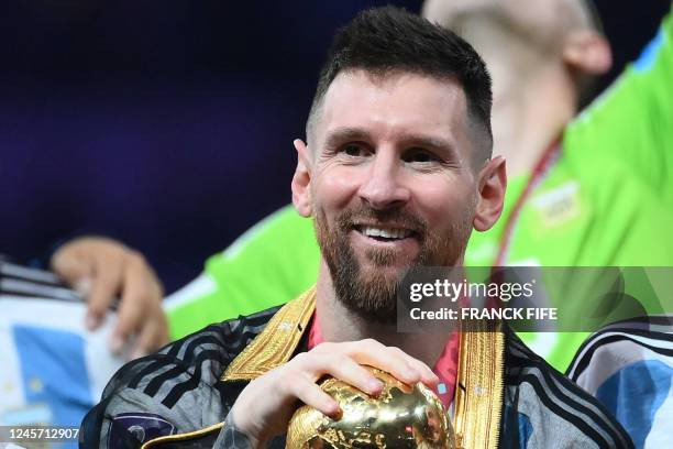 Argentina's forward Lionel Messi holds the World Cup trophy during the Qatar 2022 World Cup trophy ceremony after the football final match between...