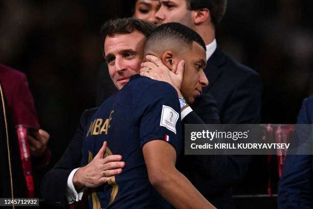 France's forward Kylian Mbappe is consoled by French President Emmanuel Macron during the trophy ceremony after France lost the Qatar 2022 World Cup...