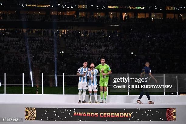 France's forward Kylian Mbappe leaves the stage after posing on the podium with Argentina's midfielder Enzo Fernandez, Argentina's forward Lionel...