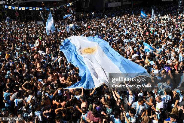 Fans of Argentina carry an Argentinian flag as they celebrate after Argentina's victory against France in the final match of FIFA World Cup Qatar...