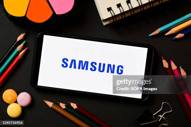 In this photo illustration a Samsung logo seen displayed on a smartphone.