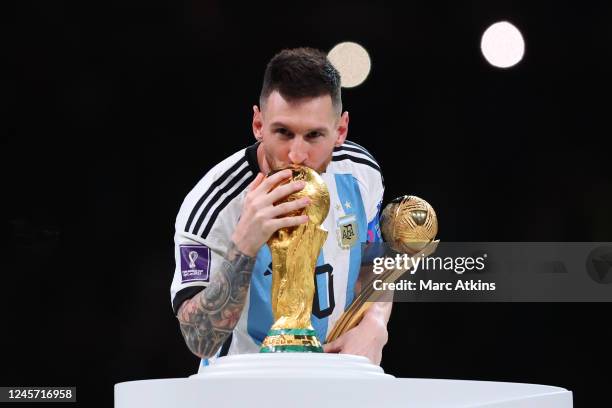 Lionel Messi of Argentina kisses the World Cup Trophy after collecting his player of the tournament award during the FIFA World Cup Qatar 2022 Final...