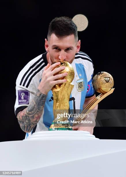 Lionel Messi of Argentina kisses the World Cup Trophy after collecting his player of the tournament award during the FIFA World Cup Qatar 2022 Final...