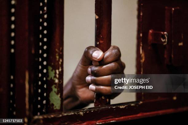 An inmate's hand is seen as she grabs at her cell's iron bars at Baabda women's prison, east of Lebanon's capital on December 12, 2022. - Lebanese...