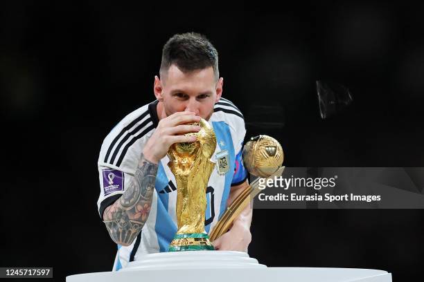Lionel Messi poses for photos with his best player trophy and World Cup 2022 trophy during the FIFA World Cup Qatar 2022 Final match between...