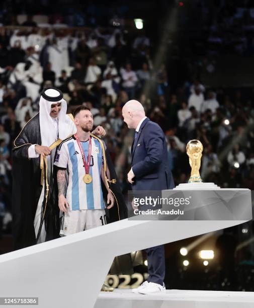 Lionel Messi of Argentina, Sheikh Tamim bin Hamad Al Thani, Emir of Qatar, and Gianni Infantino, President of FIFA are seen in the trophy...
