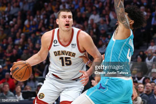 Nikola Jokic of the Denver Nuggets drives to the basket against Nick Richards of the Charlotte Hornets during the first half at Ball Arena on...