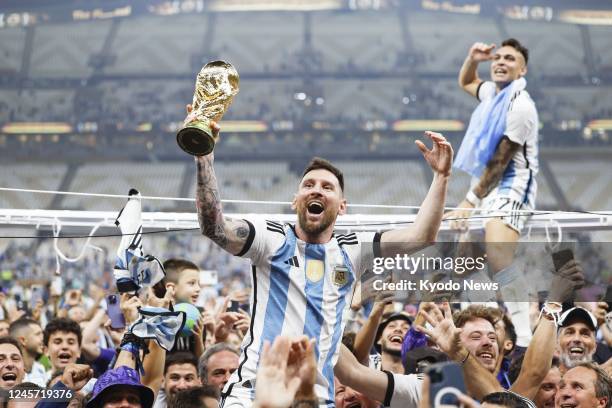 Lionel Messi celebrates with the trophy after Argentina beat France 4-2 on penalties in the World Cup football final at Lusail Stadium in Lusail,...