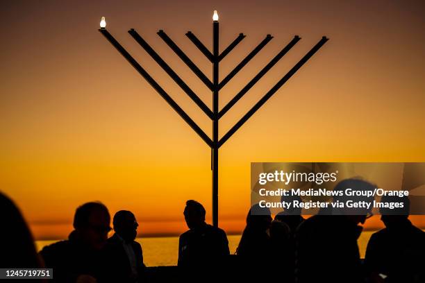 People gather around the 10-foot menorah during the Chanukah on the Pier, event at the end of the San Clemente pier hosted by Chabad of San Clemente...
