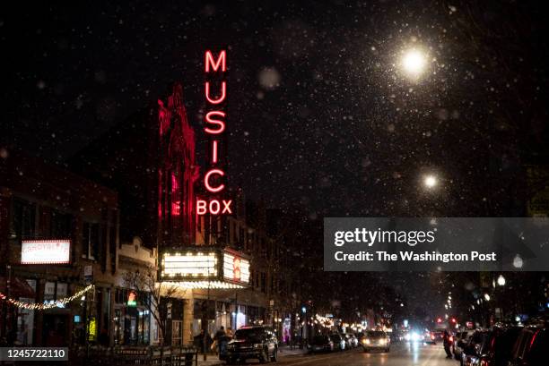 Snow falls outside the Music Box Theatre on Southport Avenue on the north side of Chicago on December 16, 2022. The theatre is known for showing...