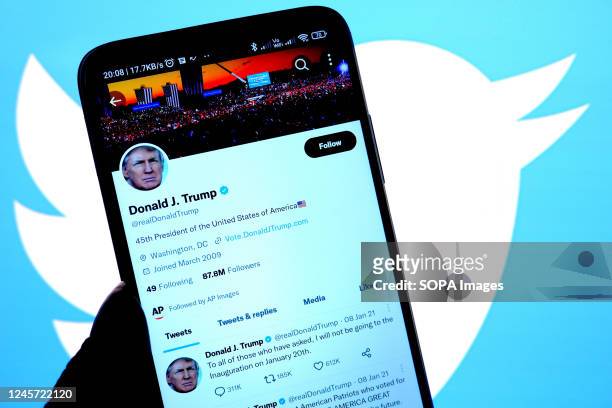 In this photo illustration, Donald Trump's twitter account seen displayed on a smartphone with a Twitter logo in the background.
