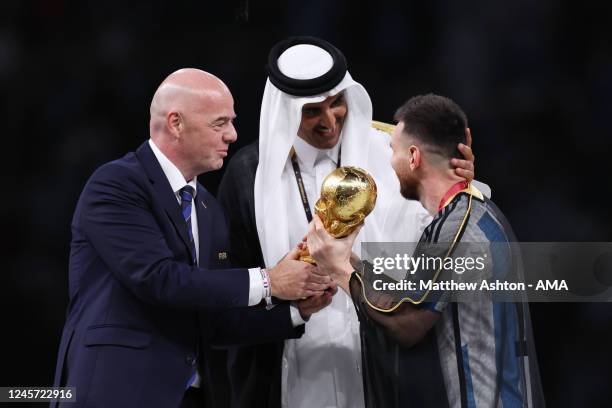 Gianni Infantino the president of FIFA and Sheikh Tamim bin Hamad Al Thani the Emir of Qatar present the FIFA World Cup Trophy to Lionel Messi of...