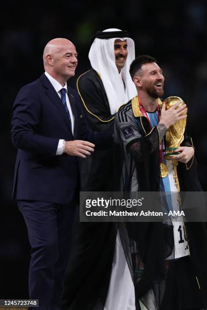 Lionel Messi of Argentina receives the FIFA World Cup Trophy from Gianni Infantino the president of FIF and HH Sheikh Tamim bin Hamad Al Thani the...