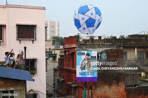 Football fans release a sky lantern with a picture of Argentina's football player Leo Messi to celebrate Argentinas victory over France in the final...