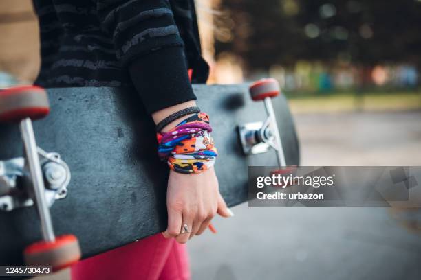 junge frau mit skateboard - unter dem arm stock-fotos und bilder
