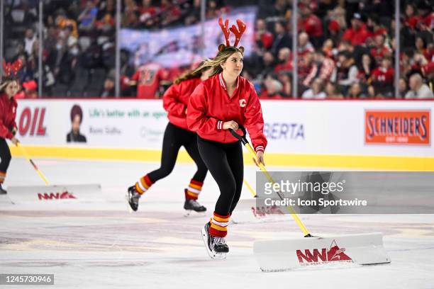 Calgary Flames ice crew members shovel snow during the first period of an NHL game between the Calgary Flames and the St. Louis Blues on December 16...