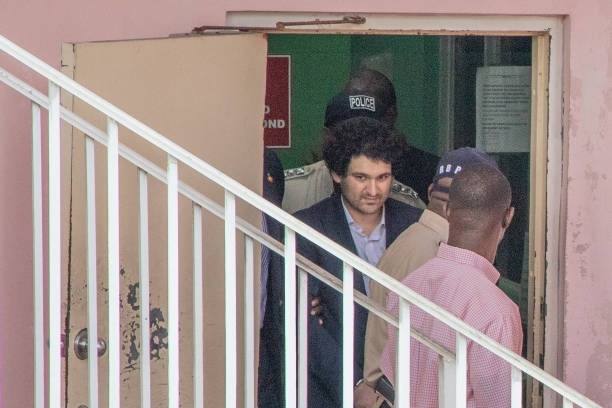 Sam Bankman-Fried, co-founder of FTX, is escorted out of the Magistrate's Court in Nassau, Bahamas, on Monday, Dec. 19, 2022. Disgraced FTX...