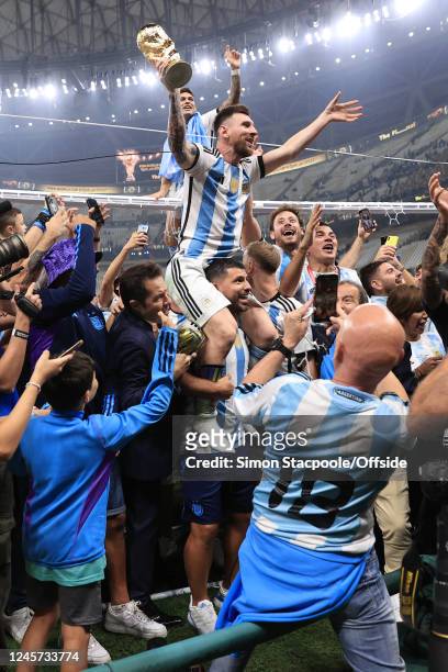 Argentina players climb the goalposts surrounded by friends and family as former player Sergio Aguero carries Lionel Messi of Argentina on his...