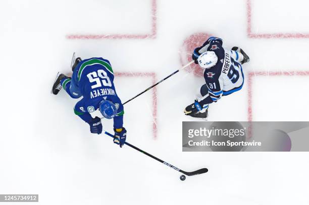 Winnipeg Jets left wing Cole Perfetti defends against Vancouver Canucks right wing Ilya Mikheyev during their NHL game at Rogers Arena on December...
