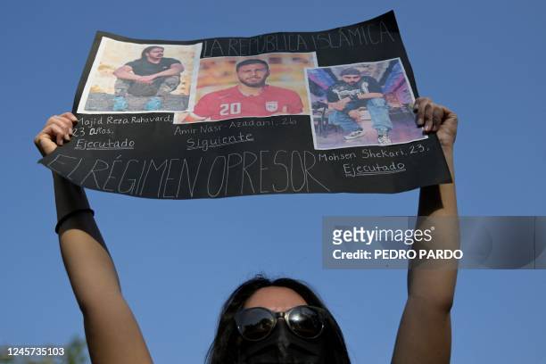 Woman holds a sign against the execution of Iranian footballer Amir Nasr-Azadani -sentenced to death in connection with protests following the death...