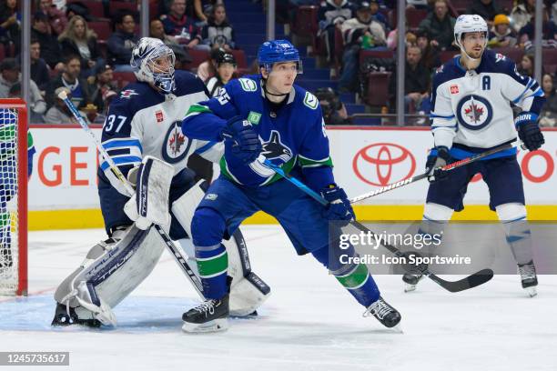 Winnipeg Jets goalie Connor Hellebuyck defends against Vancouver Canucks right wing Ilya Mikheyev during their NHL game at Rogers Arena on December...