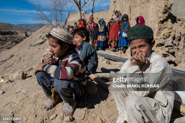 In this photo taken on December 15 Afghan boys sit outside newly built houses constructed by the United Nations refugee agency in Barmal district,...