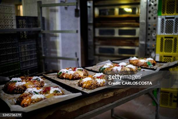 Freshly baked "Bolo-Rei" lie on tries at the Padaria da Ne bakery in Amadora, 12 km from Lisbon, on December 16, 2022. - The "Bolo Rei" ring-shaped...