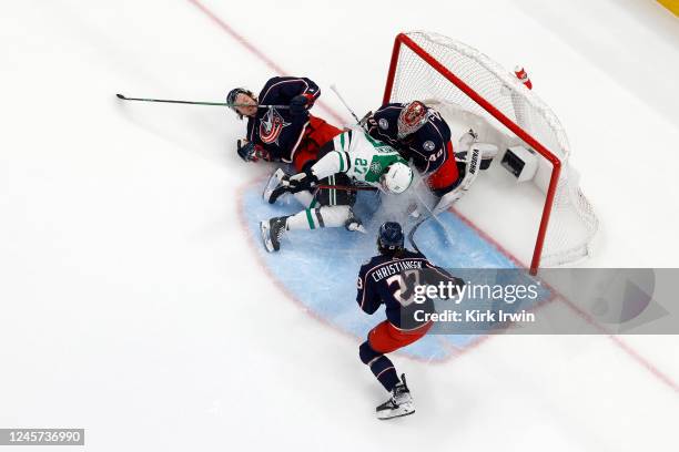 Mason Marchment of the Dallas Stars slides into Daniil Tarasov of the Columbus Blue Jackets after being tripped up by Andrew Peeke during the first...