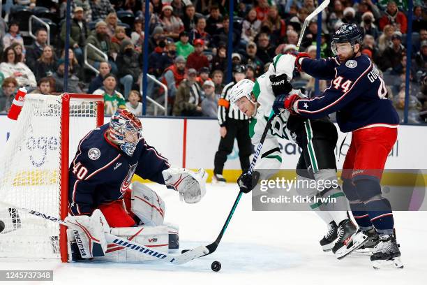 Daniil Tarasov of the Columbus Blue Jackets makes a save as Erik Gudbranson checks Ty Dellandrea of the Dallas Stars during the third period of the...