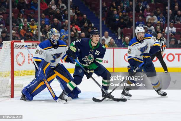 Jordan Binnington and Justin Faulk of the St. Louis Blues defend against Sheldon Dries of the Vancouver Canucks during the first period of their NHL...