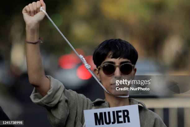 Woman holds a banner pretending to be on the gallows as she protests outside the Embassy of the Islamic Republic of Iran in Mexico City against the...