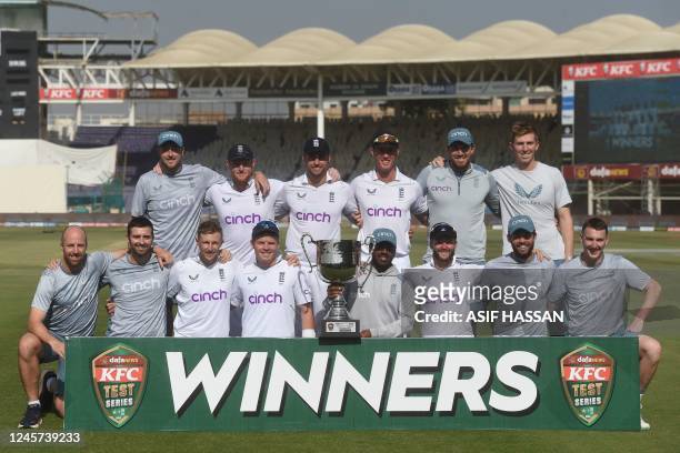 England's cricketers pose with the trophy after winning the test series at the end of fourth day of third test match between Pakistan and England at...