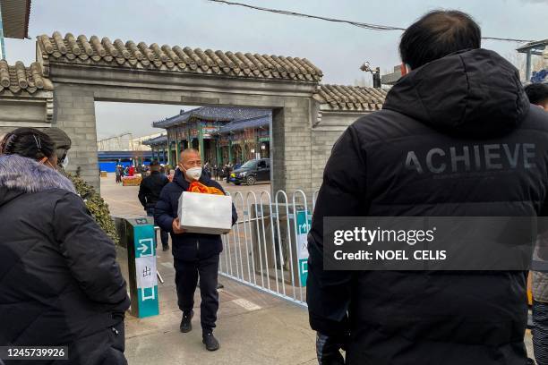 Man carries an urn of a loved one's ashes at a crematorium in Beijing on December 20, 2022. - Workers at Beijing crematoriums said on December 16...